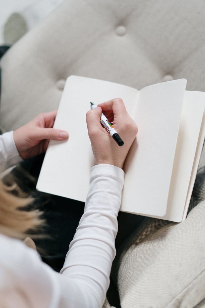 Person Writing On A Notebook